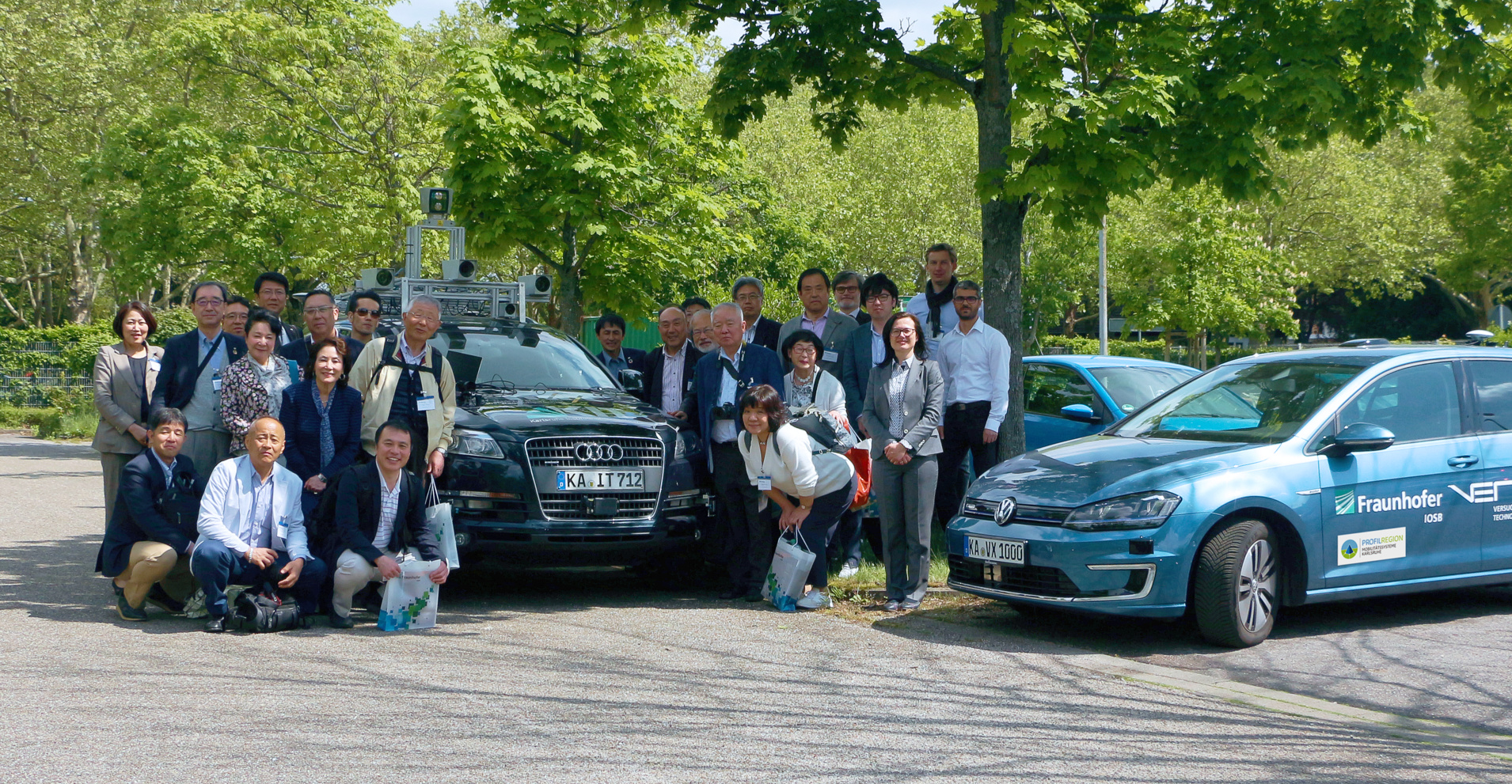 Gruppe Automative des Fraunhofer IOSB mit Wirtschaftsvertretern aus Japan und Messfahrzeug des MRT (links) und eines der VERTEX-Fahrzeuge (Versuchsfahrzeuge für Technologie-Experimente des Fraunhofer IOSB