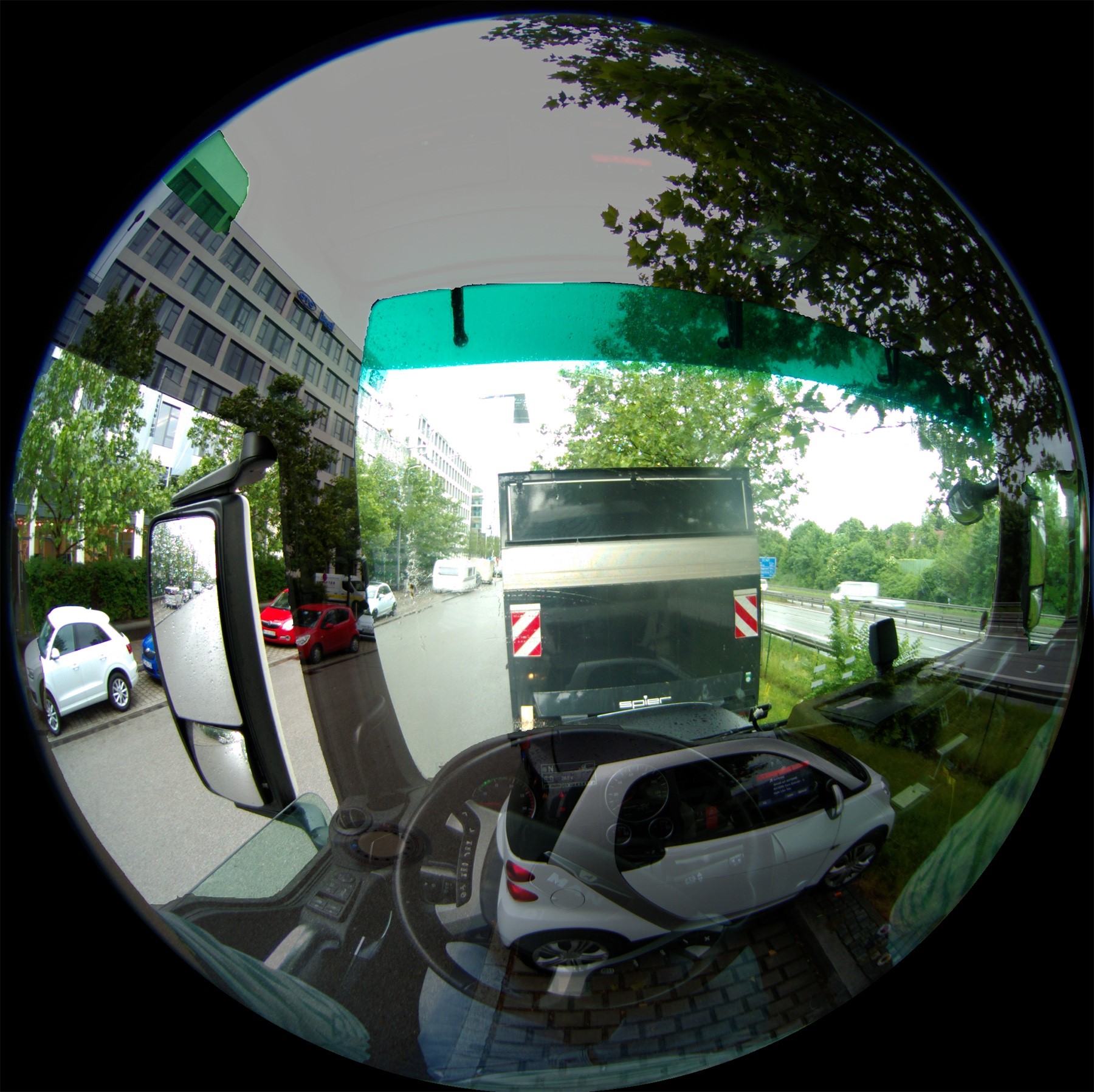 Simulierter Blick aus dem Fahrerhaus eines LKW: Transparentes Cockpit durch Überlagerung von Kameraaufnahme aus Fahrerperspektive und realer Sicht. 